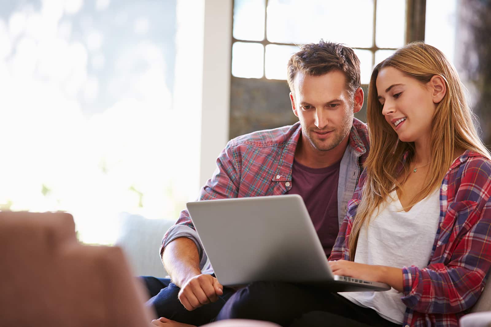 Couple At Home In Lounge Using Laptop Computer